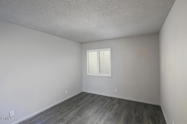 unfurnished room with a textured ceiling and dark wood-type flooring