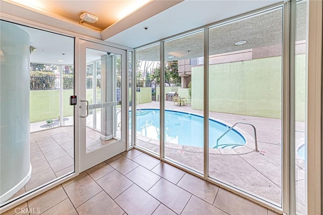 entryway with tile patterned floors and expansive windows