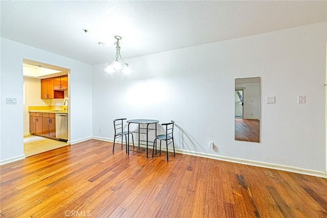 empty room featuring a chandelier, light hardwood / wood-style flooring, and sink