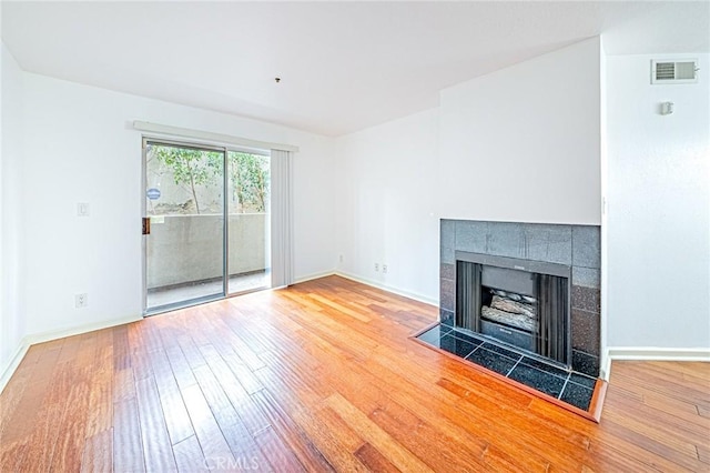 unfurnished living room featuring a fireplace and hardwood / wood-style floors