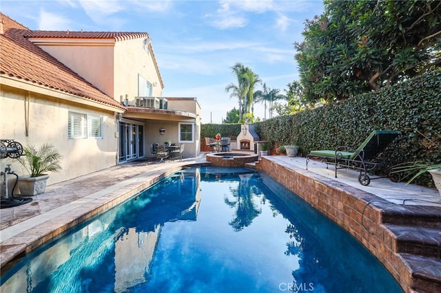 view of pool with a fireplace and a patio area