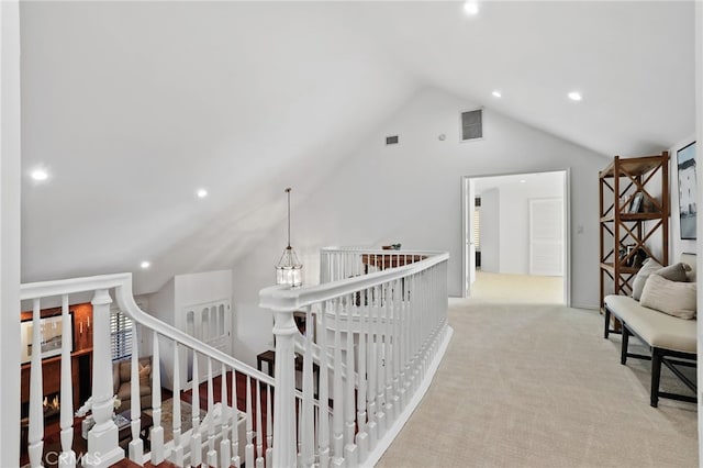 corridor featuring light colored carpet, an inviting chandelier, and lofted ceiling