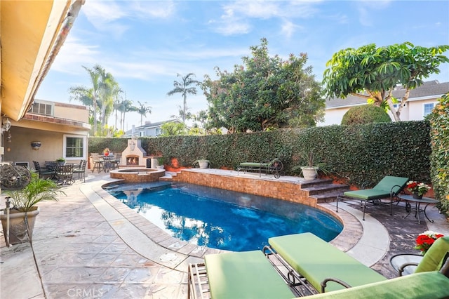 view of pool with a patio and an outdoor fireplace