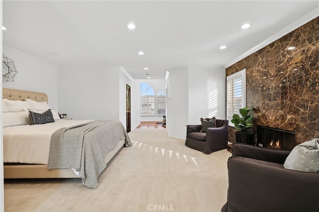 carpeted bedroom featuring a premium fireplace, crown molding, and multiple windows