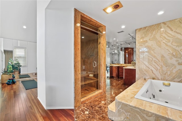 bathroom with hardwood / wood-style flooring, vanity, and separate shower and tub