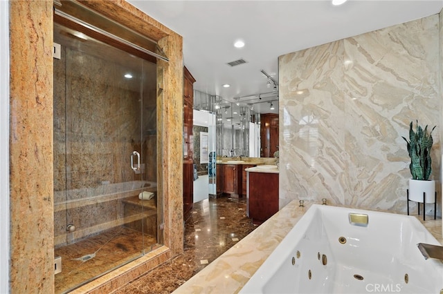 bathroom featuring plus walk in shower, vanity, and tile walls