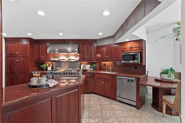 kitchen featuring backsplash, sink, wall chimney exhaust hood, ceiling fan, and stainless steel appliances