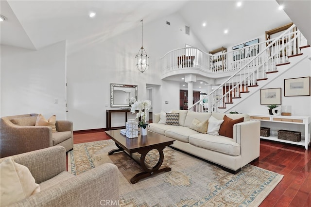 living room with high vaulted ceiling, dark wood-type flooring, and a notable chandelier