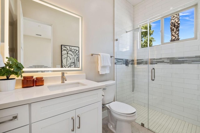 bathroom featuring vanity, toilet, and a shower with door