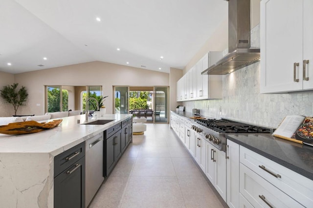 kitchen featuring sink, stainless steel appliances, white cabinetry, and wall chimney range hood