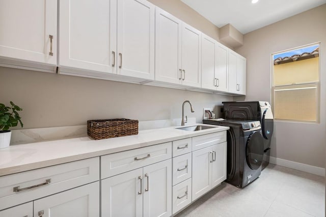 washroom featuring washer and clothes dryer, light tile patterned flooring, cabinets, and sink