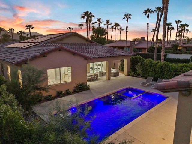 pool at dusk featuring a patio area