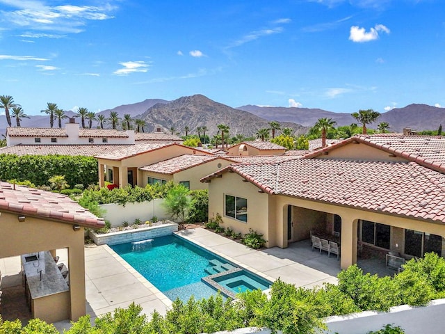 view of swimming pool with a mountain view, a patio, and an in ground hot tub