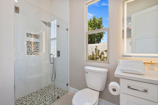 bathroom featuring vanity, toilet, and a shower with door