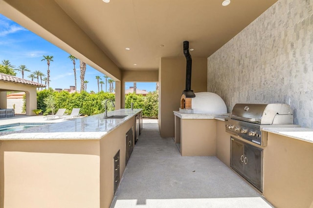 view of patio with area for grilling, sink, and an outdoor kitchen