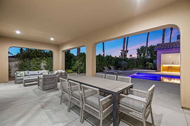 patio terrace at dusk featuring an outdoor living space