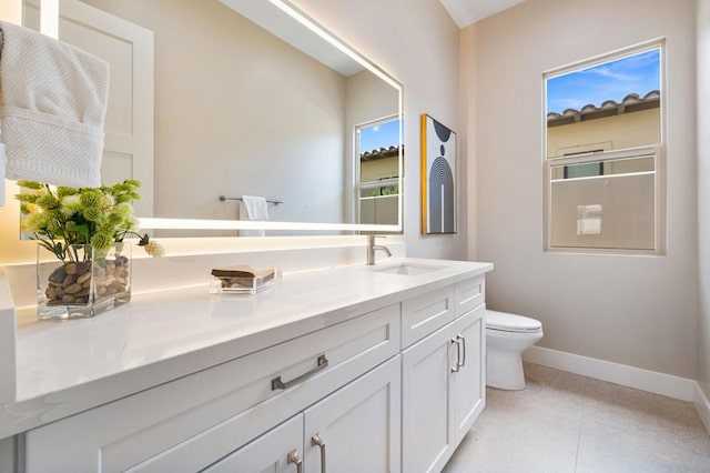 bathroom with tile patterned flooring, vanity, and toilet