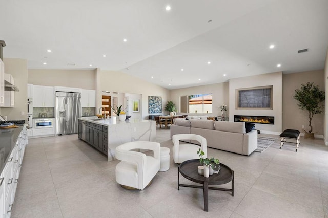 living room featuring sink and vaulted ceiling