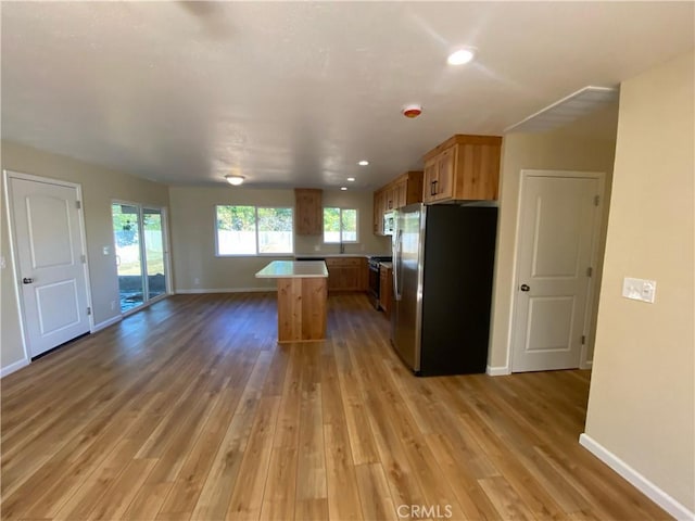 kitchen with a kitchen island, wood-type flooring, and appliances with stainless steel finishes