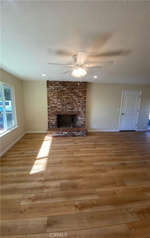 1954 Durham Dayton, Durham, CA 95938 - unfurnished living room with a ceiling fan, wood finished floors, a brick fireplace, a textured ceiling, and recessed lighting