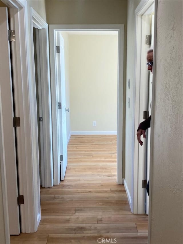 corridor with light wood-type flooring