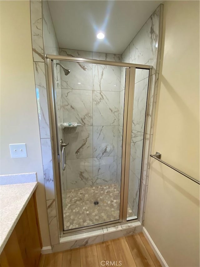 bathroom with vanity, wood-type flooring, and walk in shower