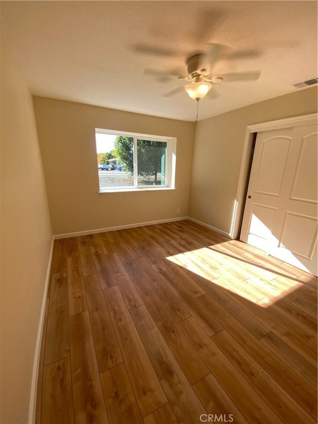 empty room with wood-type flooring and ceiling fan