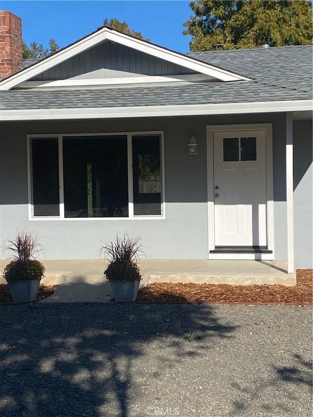 view of exterior entry featuring covered porch