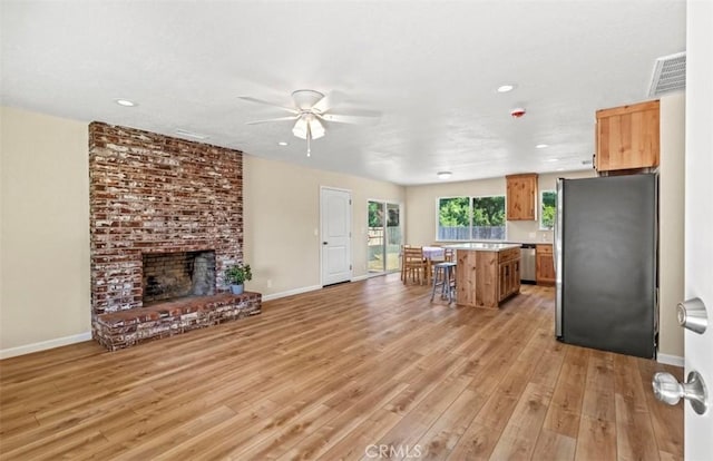1954 Durham Dayton, Durham, CA 95938 - kitchen featuring appliances with stainless steel finishes, a kitchen island, a kitchen bar, light wood-style flooring, and a ceiling fan