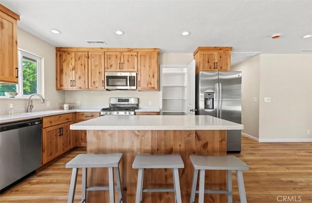 1954 Durham Dayton, Durham, CA 95938 - kitchen with appliances with stainless steel finishes, light wood-style floors, a kitchen bar, light countertops, and recessed lighting