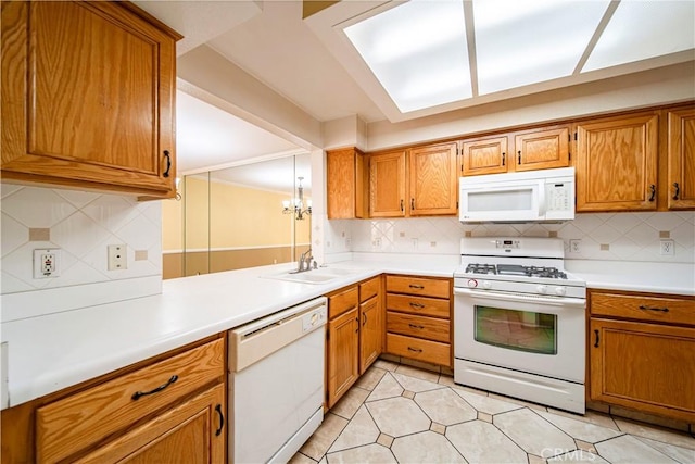 kitchen with tasteful backsplash, white appliances, sink, an inviting chandelier, and light tile patterned flooring