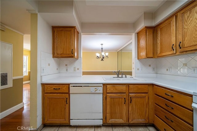 kitchen with decorative backsplash, sink, decorative light fixtures, an inviting chandelier, and dishwasher