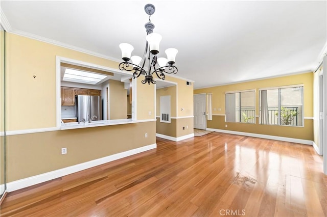 interior space featuring a chandelier, light hardwood / wood-style floors, and ornamental molding