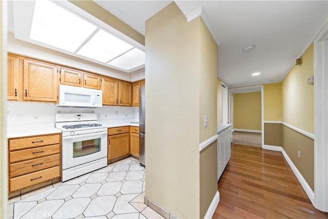 kitchen with white appliances, tasteful backsplash, light hardwood / wood-style flooring, and ornamental molding