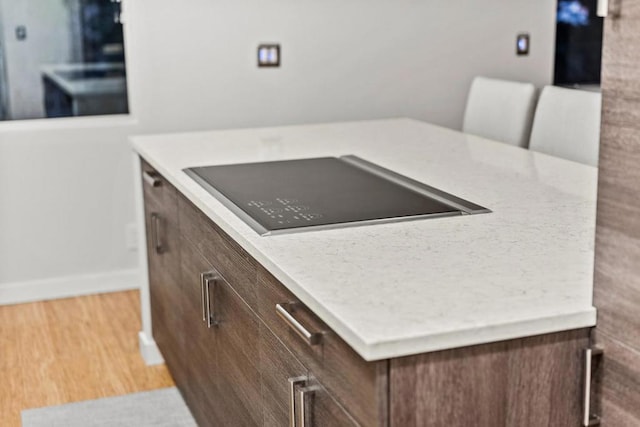 kitchen with black electric stovetop, light hardwood / wood-style floors, and a kitchen island