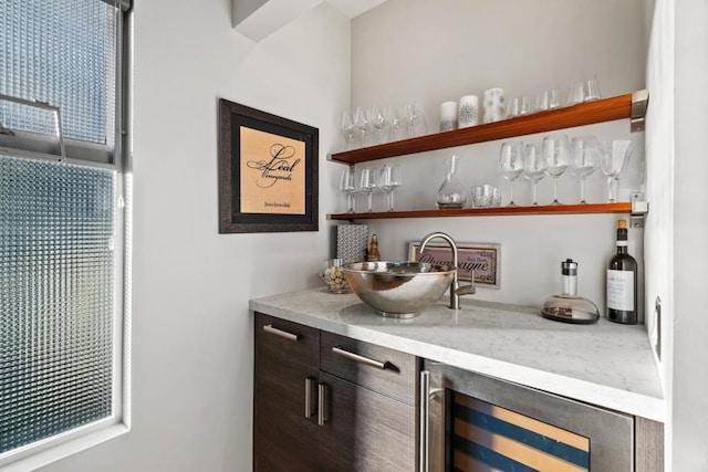 bar with dark brown cabinets, a wealth of natural light, and wine cooler