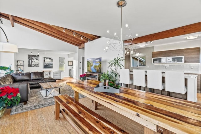 dining space with high vaulted ceiling, light hardwood / wood-style flooring, beamed ceiling, and an inviting chandelier