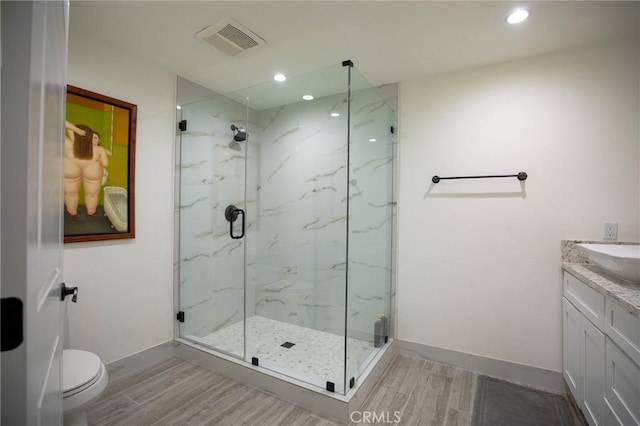 bathroom with vanity, hardwood / wood-style flooring, toilet, and walk in shower