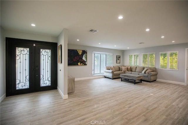 entryway featuring plenty of natural light, french doors, and light hardwood / wood-style flooring