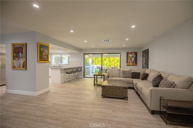 living room featuring sink and light hardwood / wood-style floors