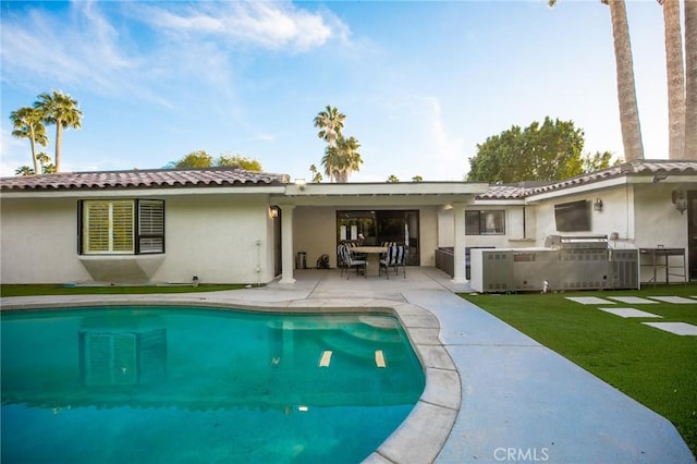 back of property featuring a patio area and a lawn