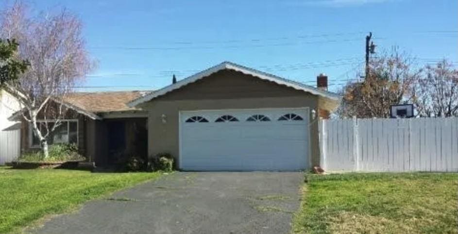 single story home featuring a front yard and a garage