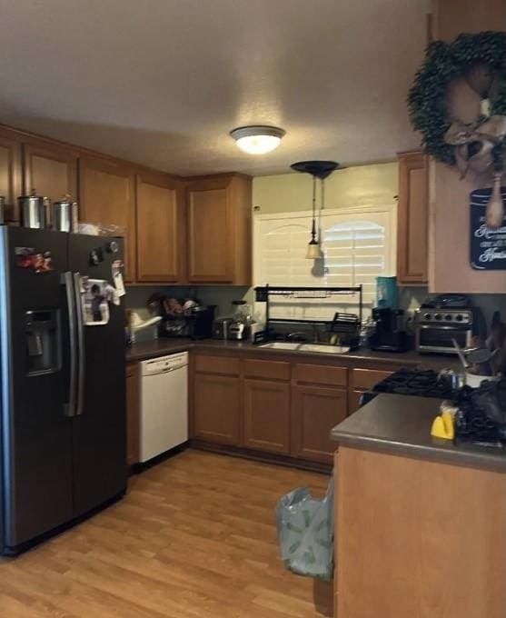 kitchen with sink, white dishwasher, black fridge, and light hardwood / wood-style flooring