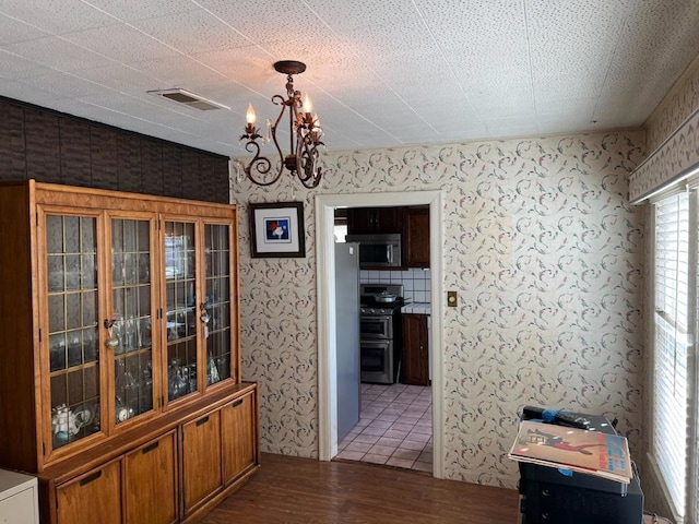 dining space with dark hardwood / wood-style flooring, a chandelier, and a textured ceiling