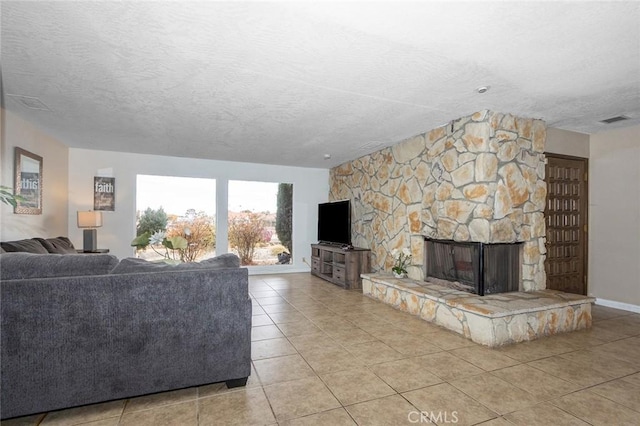 living room with a fireplace, light tile patterned floors, and a textured ceiling