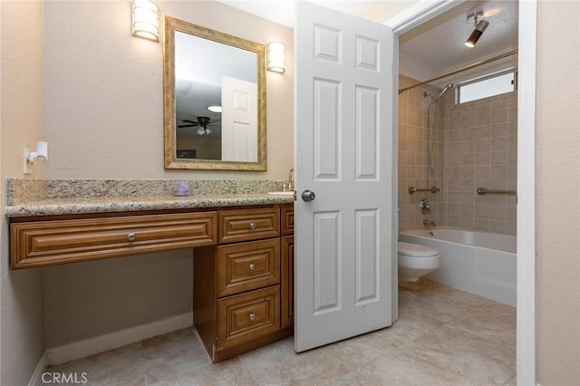 full bathroom featuring vanity, tiled shower / bath combo, and toilet