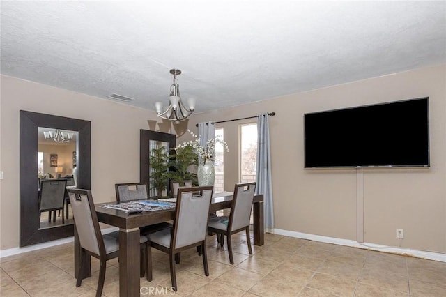 tiled dining space featuring a notable chandelier