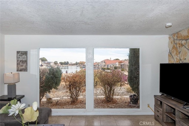 doorway with a textured ceiling and light tile patterned flooring