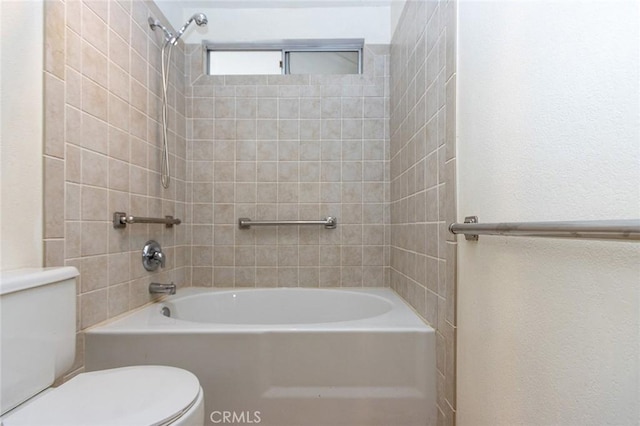 bathroom with tiled shower / bath combo and toilet