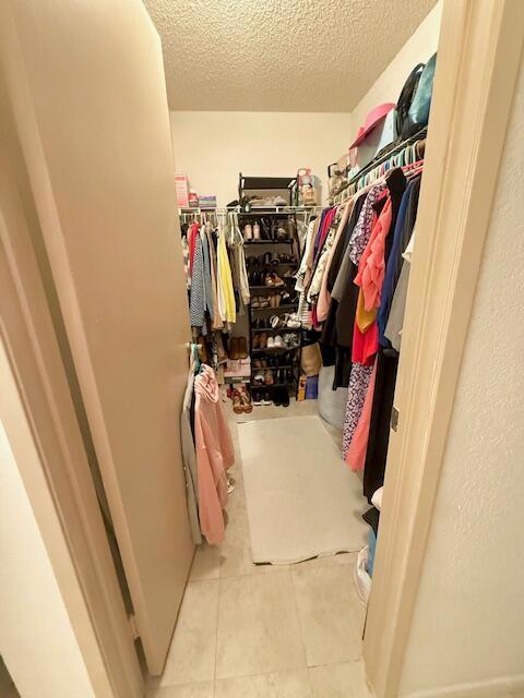 spacious closet with light tile patterned floors